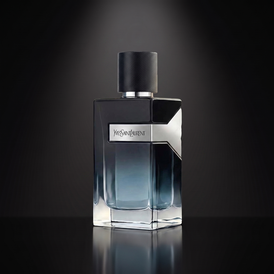 YSL Y EDP — frasco sobre superficie negra reflectante con fondo carbón