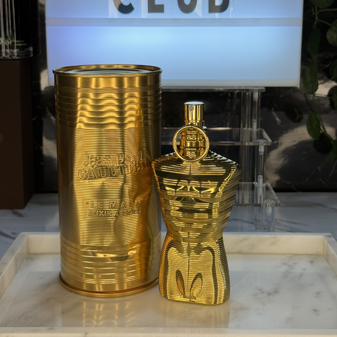 Jean Paul Gaultier Le Male Elixir Absolu — frasco original sobre superficie negra reflectante con fondo carbón, Parfaria Club