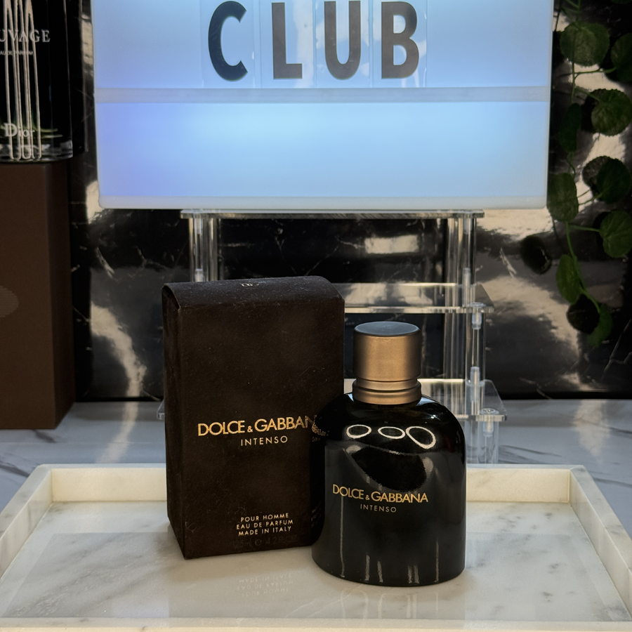 Dolce & Gabbana Intenso Pour Homme — frasco original sobre superficie negra reflectante con fondo carbón, Parfaria Club