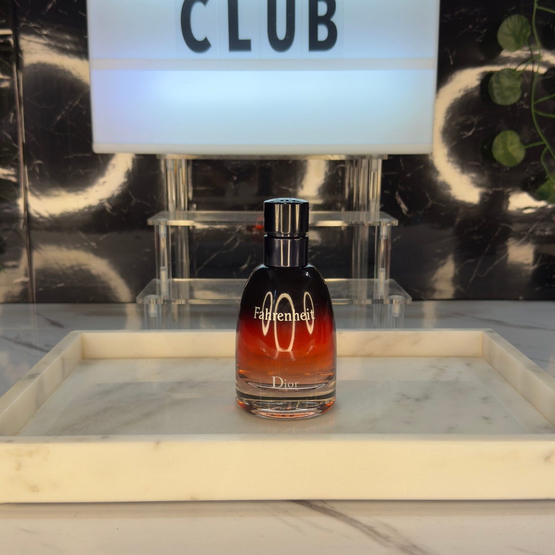 Dior Fahrenheit Parfum — frasco original sobre superficie negra reflectante con fondo carbón, Parfaria Club