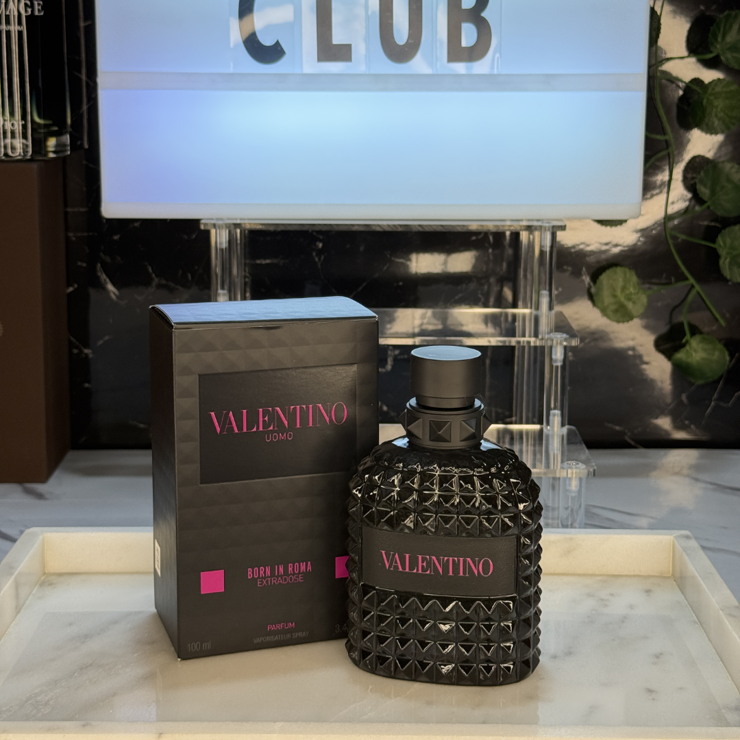 Valentino Born in Roma Extradose — frasco original sobre superficie negra reflectante con fondo carbón, Parfaria Club
