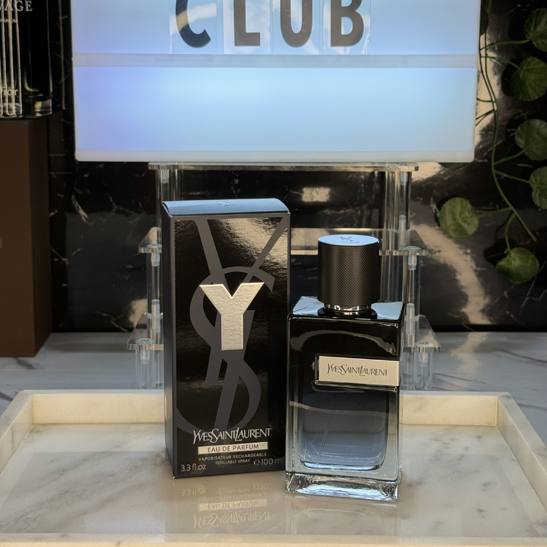 YSL Y Eau de Parfum — frasco original sobre superficie negra reflectante con fondo carbón, Parfaria Club