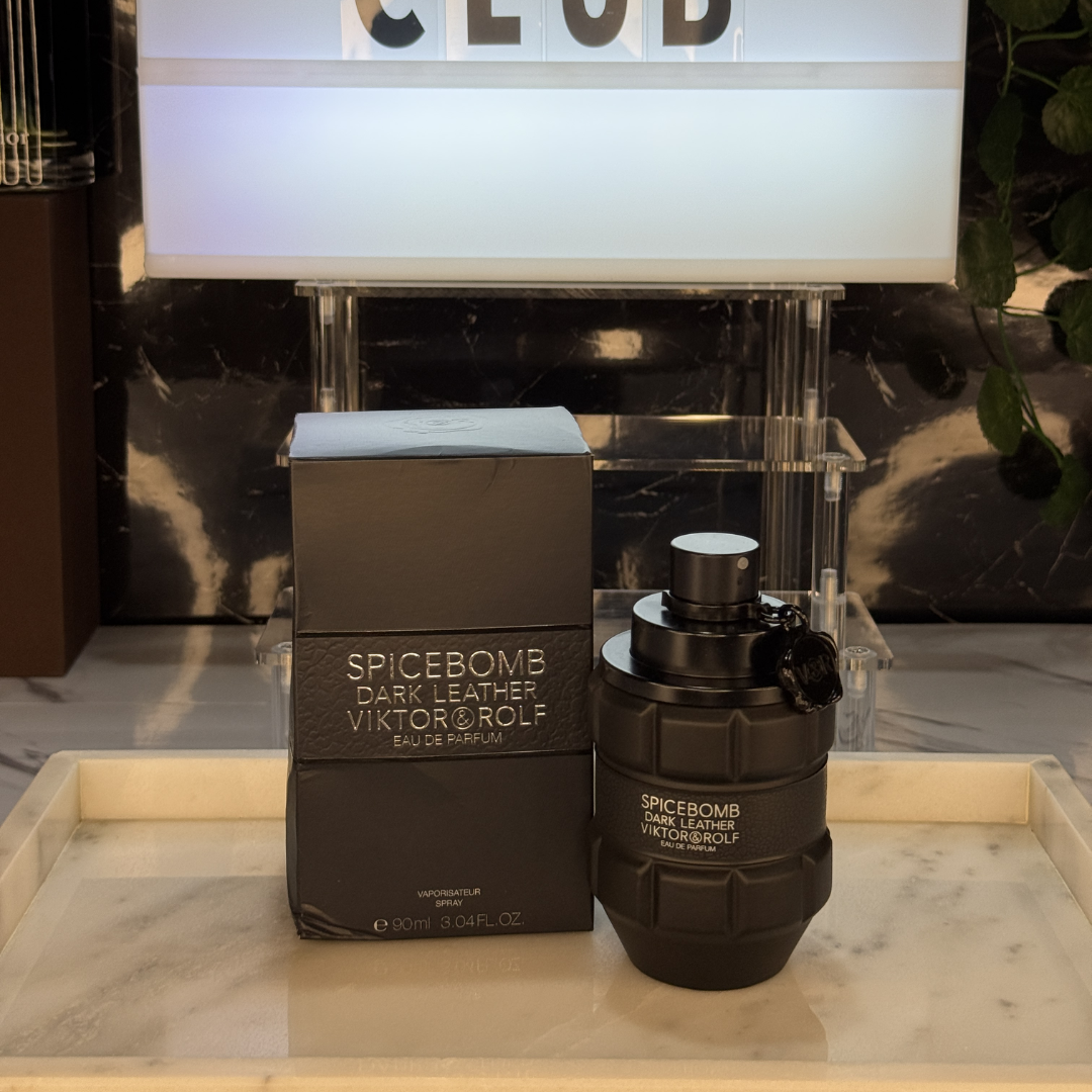 Viktor & Rolf Spicebomb Dark Leather — frasco original sobre superficie negra reflectante con fondo carbón, Parfaria Club