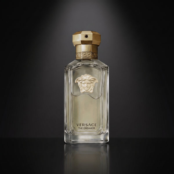 Versace The Dreamer — frasco sobre superficie negra reflectante con fondo carbón