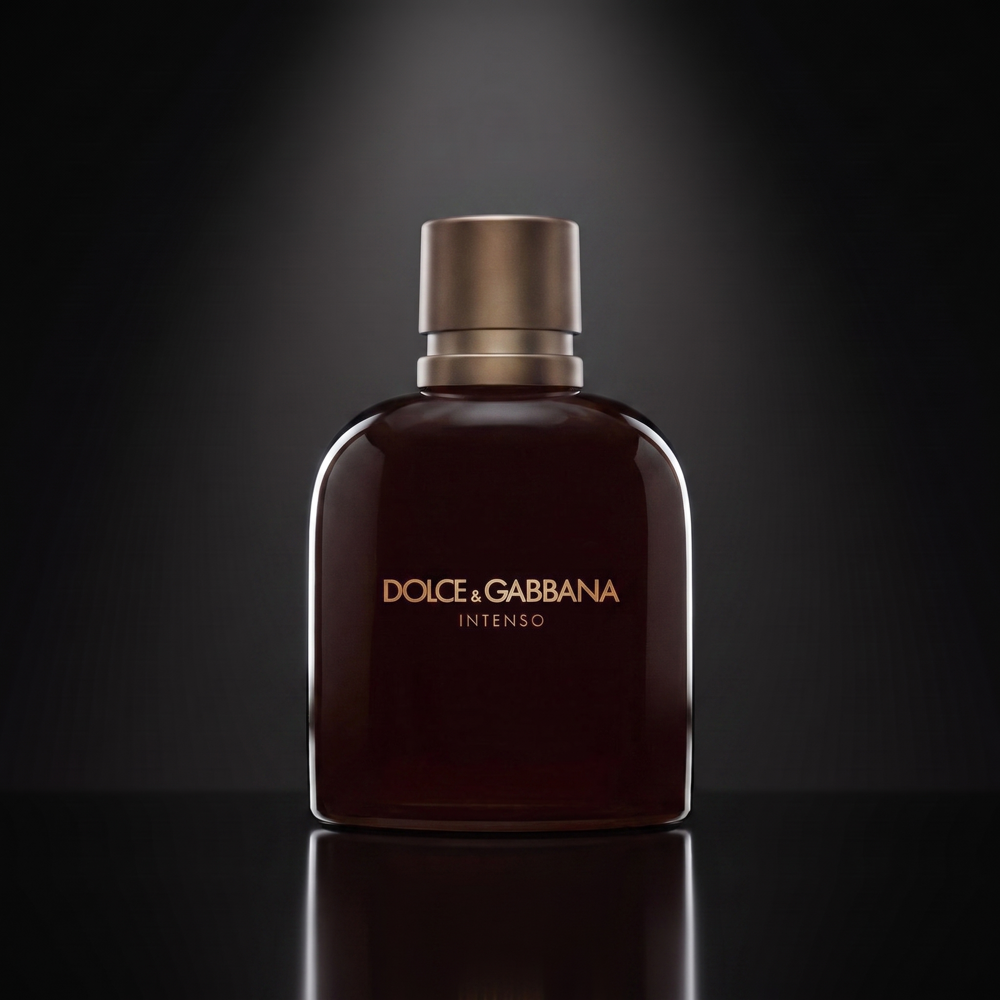 D&G Intenso Pour Homme — frasco sobre superficie negra reflectante con fondo carbón